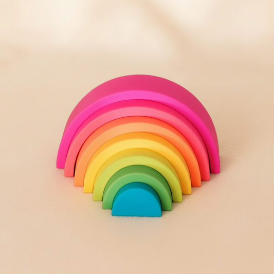 Fluorescent silicone stacking rainbow toy - Raar branded product shot on warm blush surface